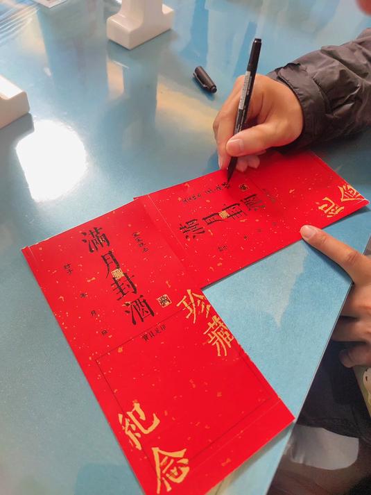 广西钦州:婴儿宝宝的满月仪式,护士姐姐指导爸爸写下满月祝福语