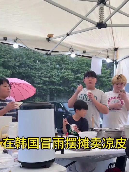 在韩国冒雨摆摊卖凉皮