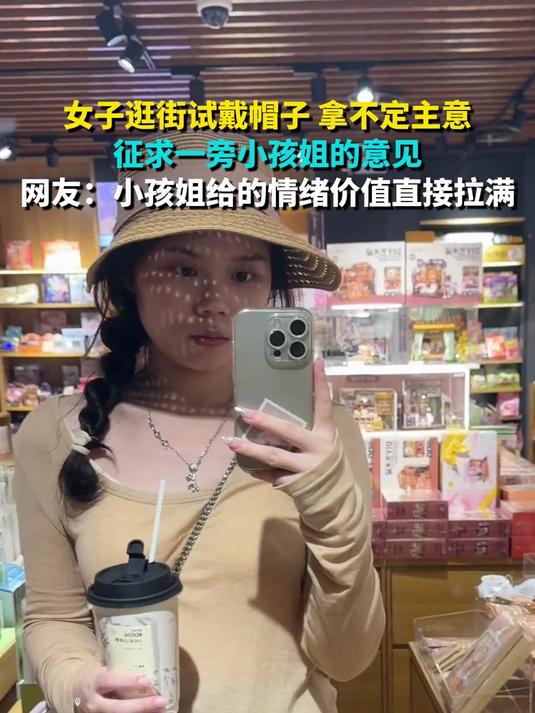 女子逛街试戴帽子 拿不定主意 征求一旁小孩姐的意见 网友：小孩姐给的情绪价值直接拉满