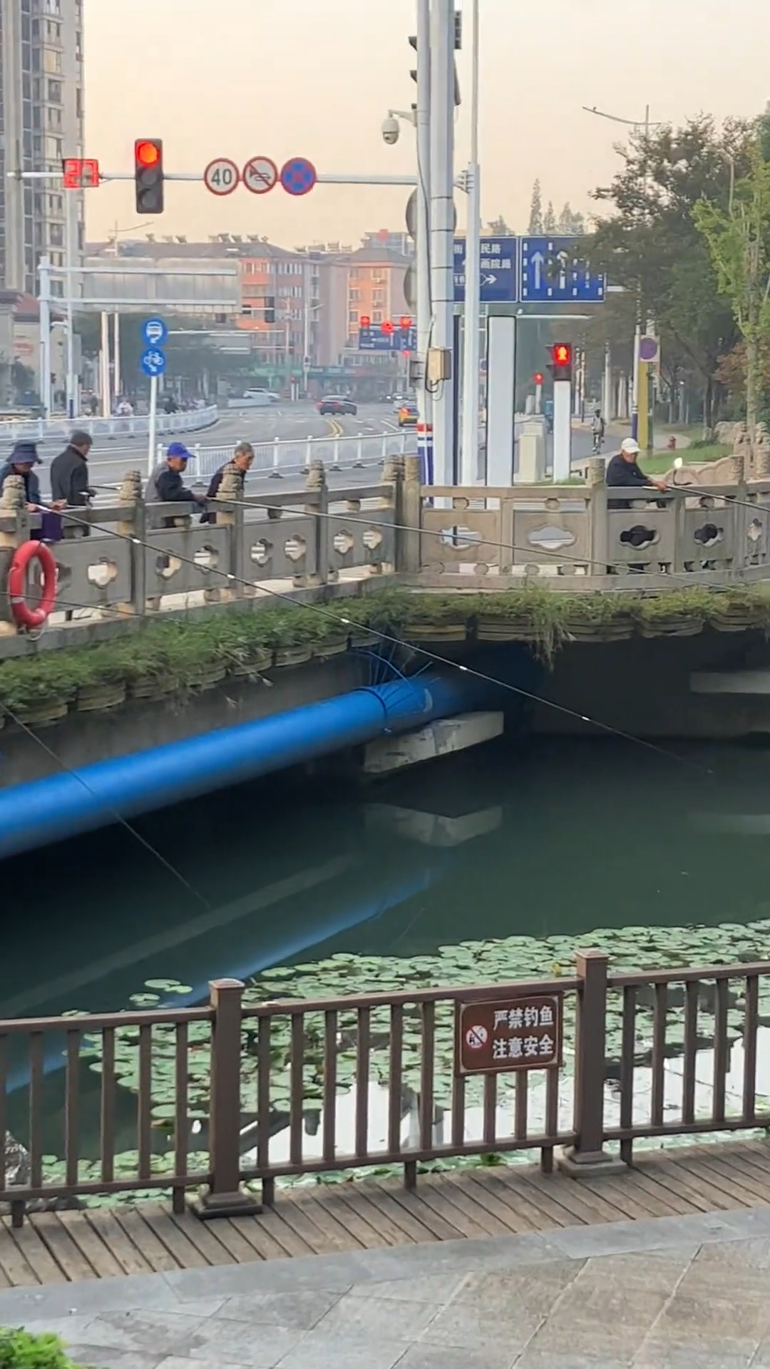 公园牌子写禁止钓鱼却仍挡不住一群钓鱼人扎堆钓鱼,保安无可奈何