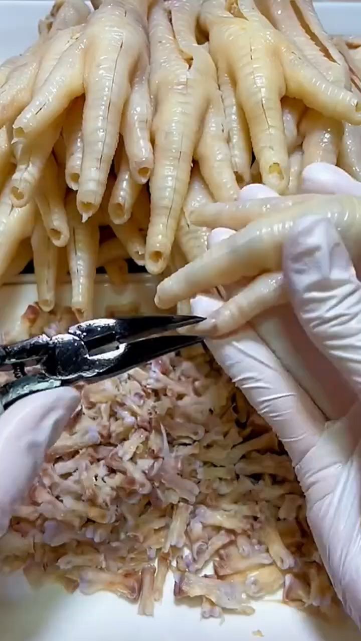人工给无骨鸡爪去骨。