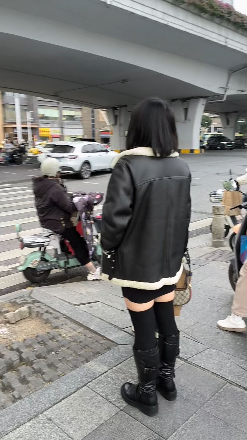 这个小姐姐穿的很酷,黑色皮毛一体外套配短裤,保暖帅气