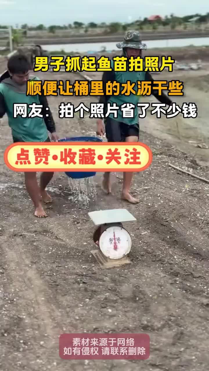 男子抓起鱼苗拍照片,顺便让桶里的水沥干些