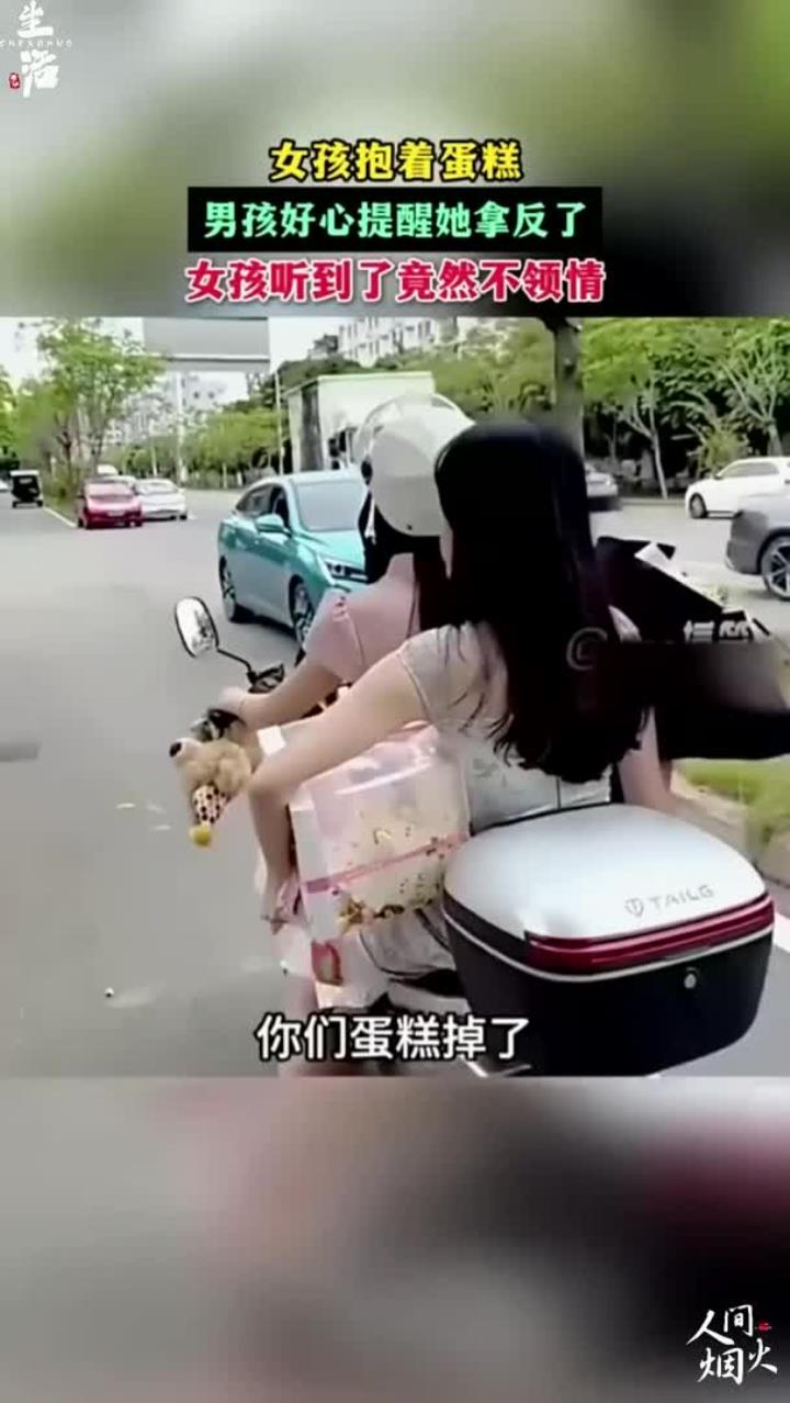 男孩好心提醒她蛋糕拿反了,结果小姐姐不领情