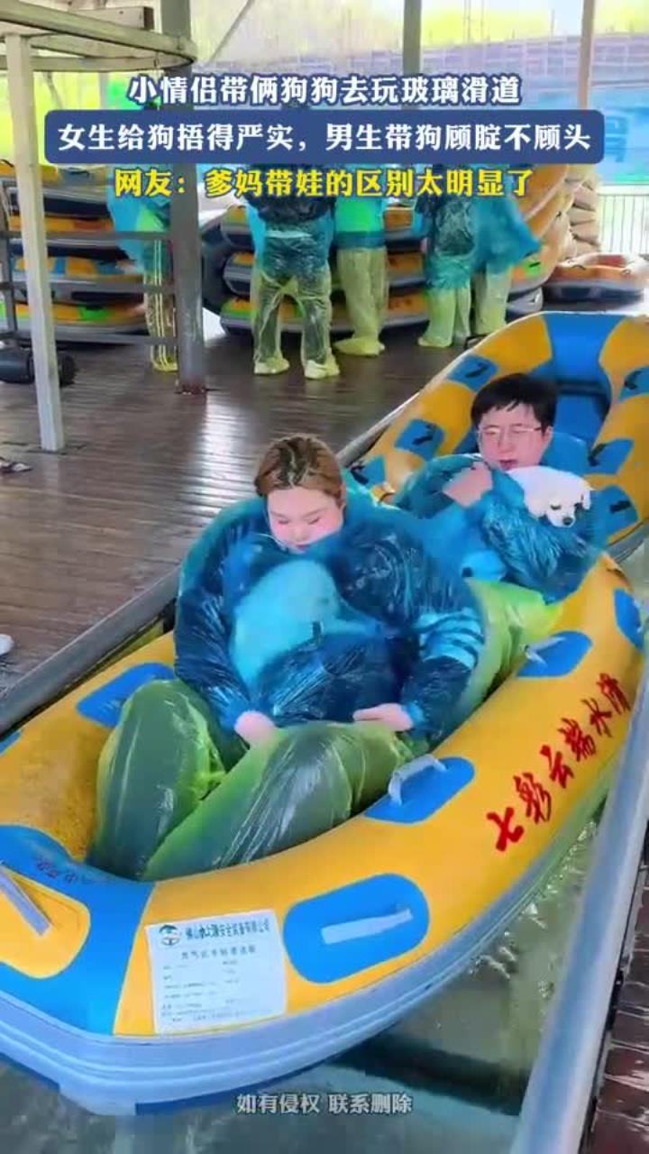 小情侣带狗狗去玩玻璃滑道,女生给狗捂严实,男生带狗顾腚不顾头
