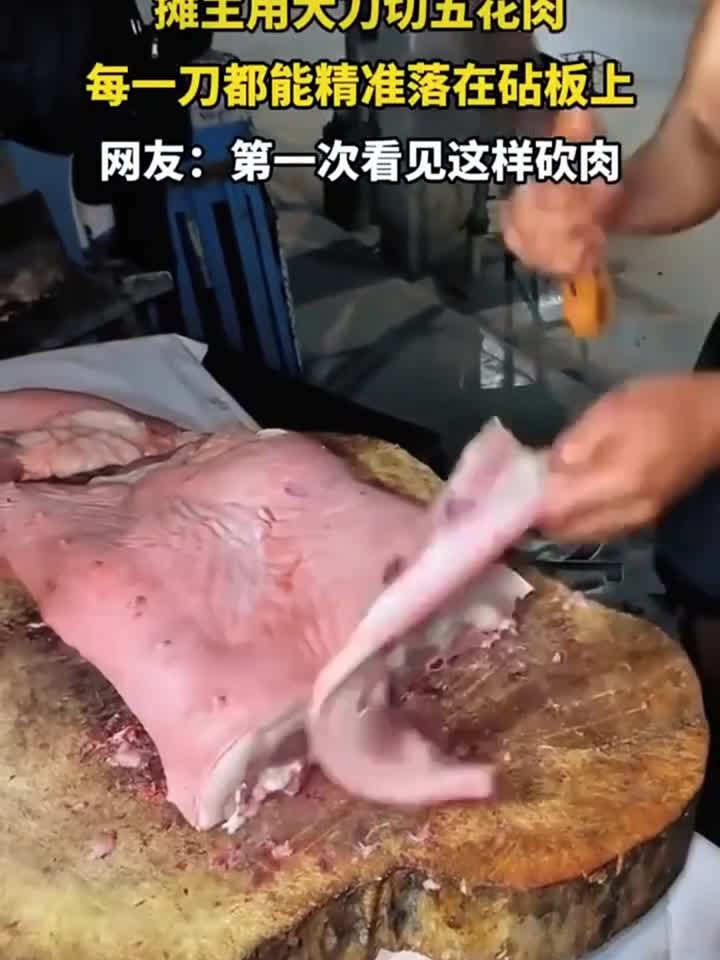 摊主用大刀切五花肉,每一刀都能精准的落在菜板上