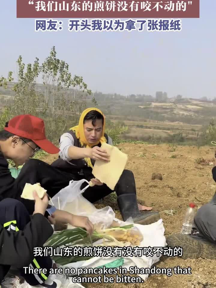 男子给同伴分享山东煎饼，我们山东的煎饼没有咬不动的