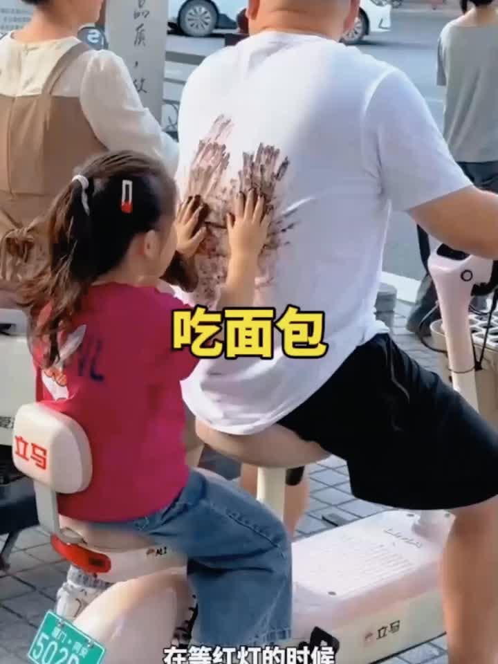 小女孩坐在车子后面吃面包