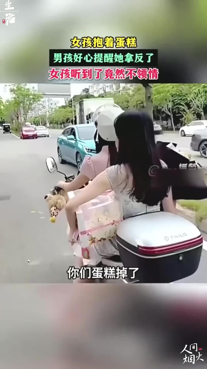 男孩好心提醒她蛋糕拿反了,结果小姐姐不领情