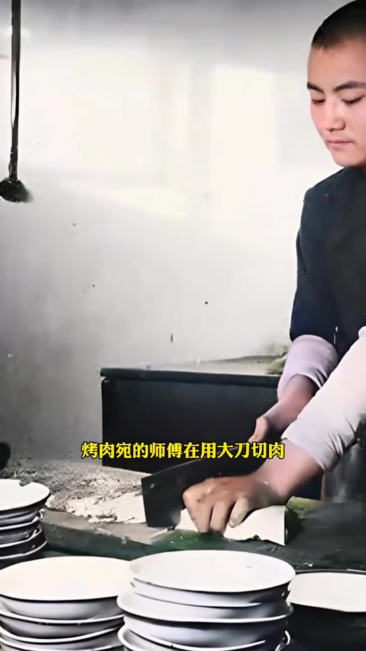 这是老北京最有名的烤牛肉铺子烤肉宛的师傅在用大刀切肉