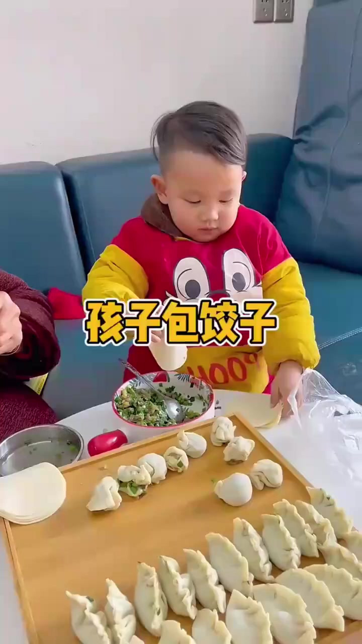 现在的孩子真是人小鬼大,竟然学着奶奶包饺子,太可爱了