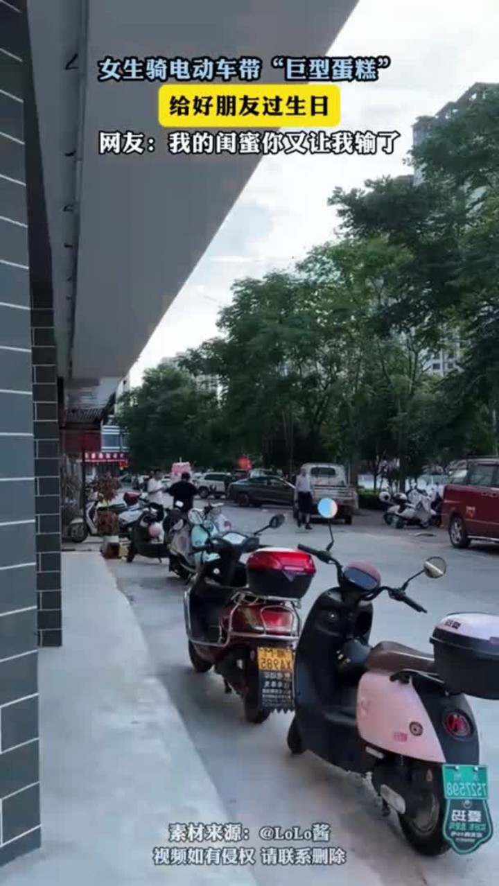 女生骑电动车带“巨型蛋糕” 给好朋友过生日