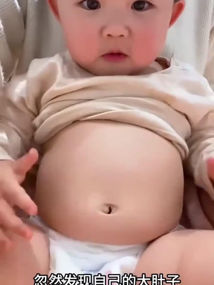 萌宝对着镜子发现大肚子,捏着肚子可爱表情引人发笑