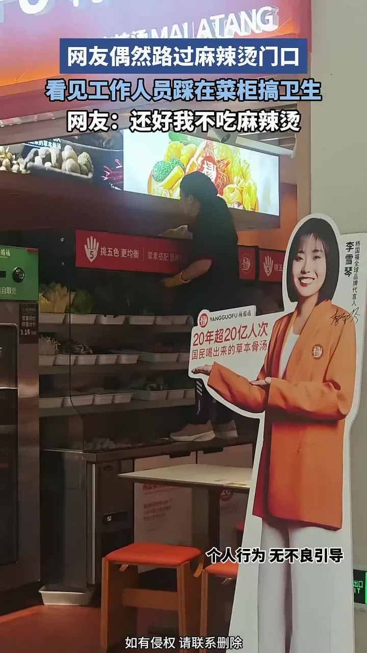 网友偶然路过麻辣烫门口,看见工作人员,踩在菜柜搞卫生