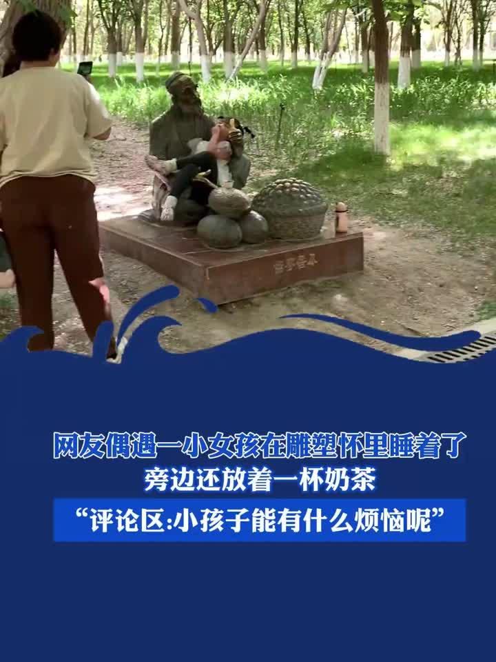 网友偶遇一小女孩在雕塑怀里睡着了，旁边还放着一杯奶茶