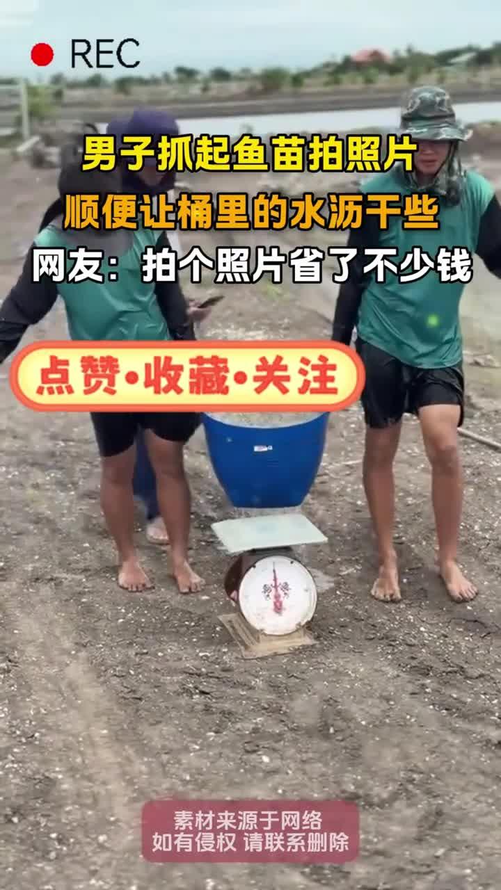 男子抓起鱼苗拍照片,顺便让桶里的水沥干些