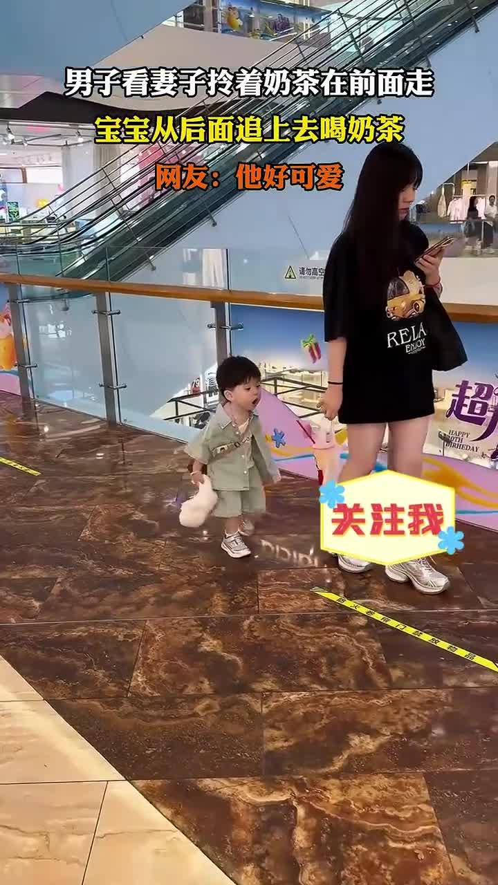 男子看妻子拎着奶茶在前面走，宝宝从后面追上去喝奶茶