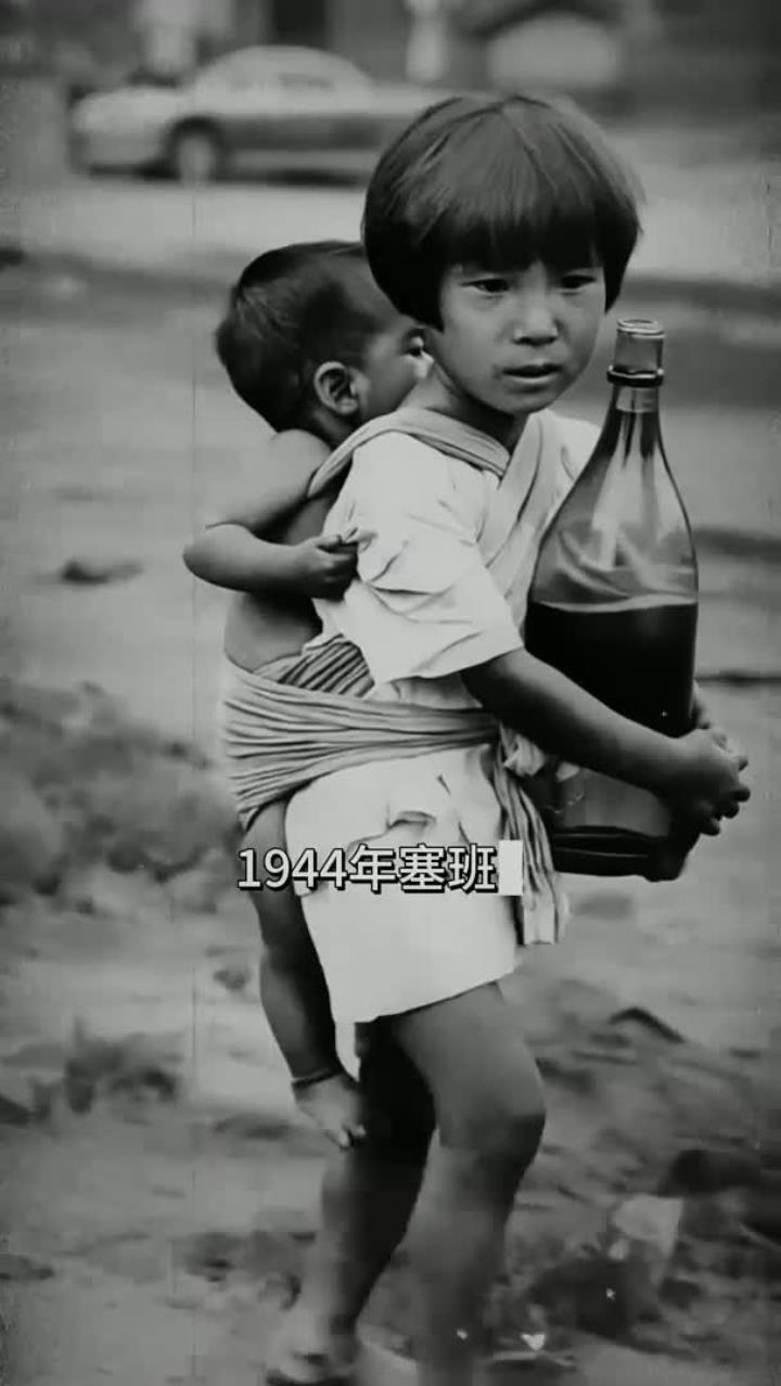1944年塞班岛一个抱着水瓶的女孩背着弟弟