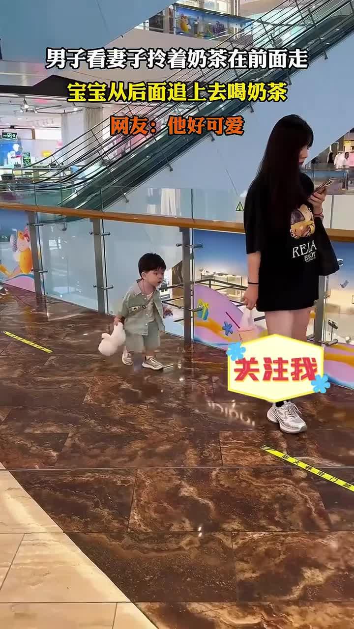 男子看妻子拎着奶茶在前面走，宝宝从后面追上去喝奶茶