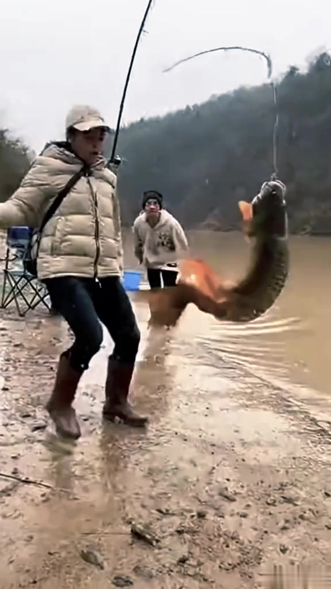 钓鱼竿钓到巨鱼，鱼挣扎时甩人一脸泥