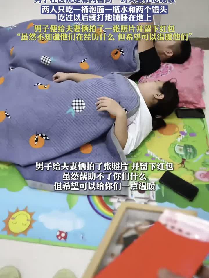 在医院走廊内一对夫妻在吃晚饭,两人吃一桶泡面一瓶水和两个馒头