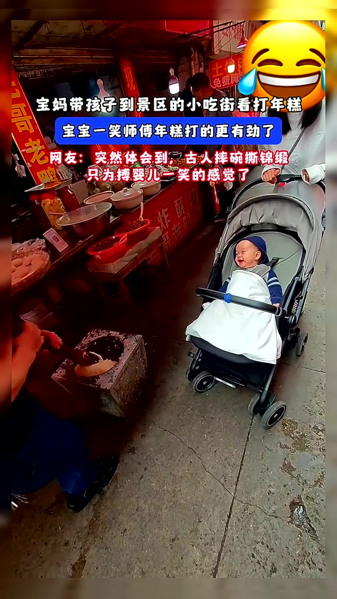 宝妈带孩子到景区的小吃街看打年糕,宝宝一笑师傅年糕打的更有劲