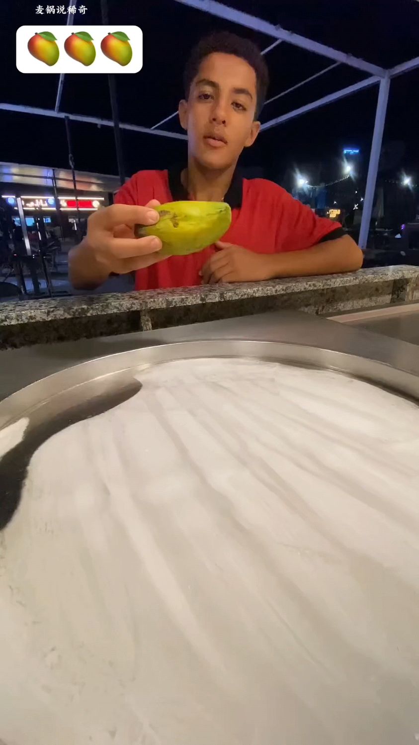 小伙喜欢吃芒果,于是让摆摊的男人,给他制作一份芒果甜点