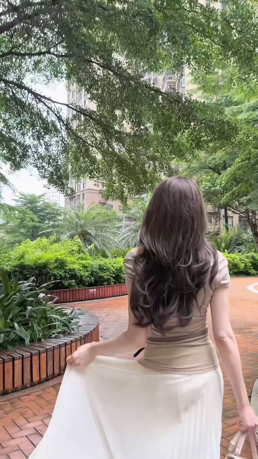 奶茶色短上衣配白色百褶长裙 随风飘动的裙摆和温柔的背影