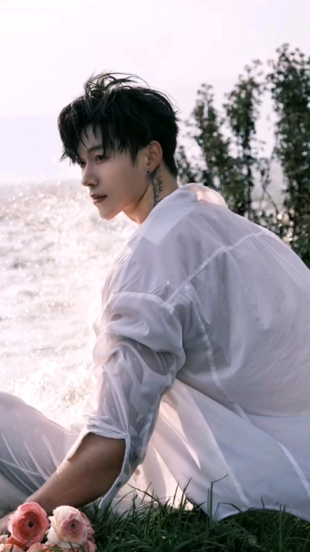 哇哦!白衣肌肉男手持鲜花海边写真,露胸肌展青春,能当你老公吗