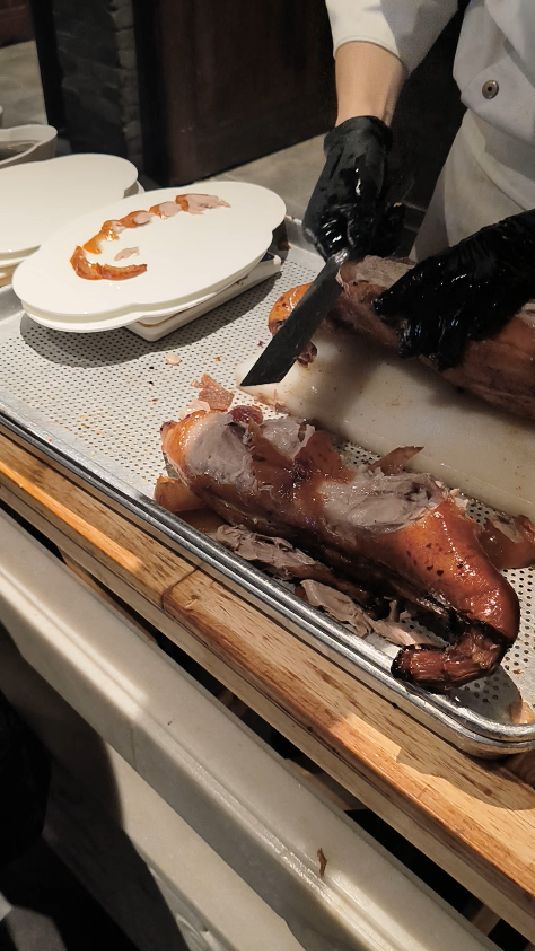 看专业厨师在餐桌上精准切割烤鸭,享受摆盘的乐趣