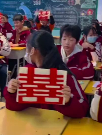 学生们学习剪纸,每个人都剪出大红喜字给老师当结婚礼物