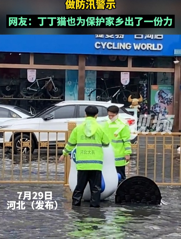 暴雨致道路积水,应急救援人员借奶茶店的吉祥物做防汛警示。网友:丁丁猫也为保护家乡出了一份力