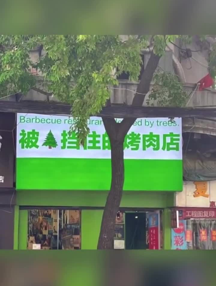 被树挡住的烤肉店logo