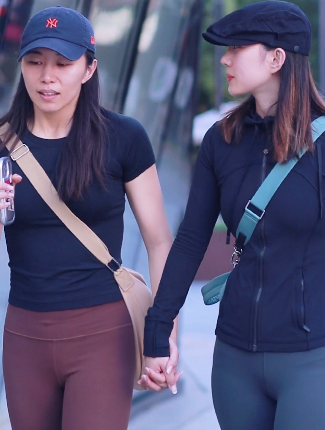 健身美女手挽手同穿瑜伽裤,棒球帽鸭舌帽风格迥异大不同