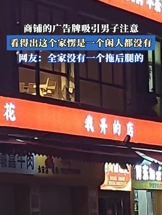 商铺的广告牌吸引男子注意,看得出这个家愣是一个闲人都没有