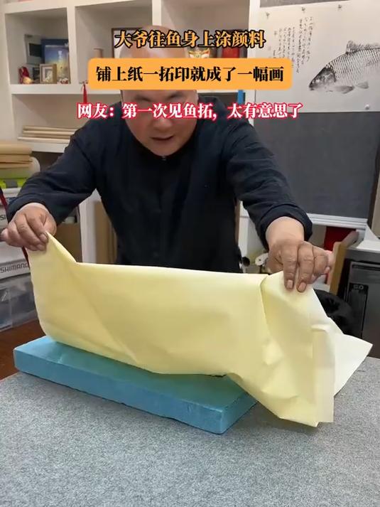 大爷往鱼身上涂颜料，铺上纸一拓印就成了一幅画