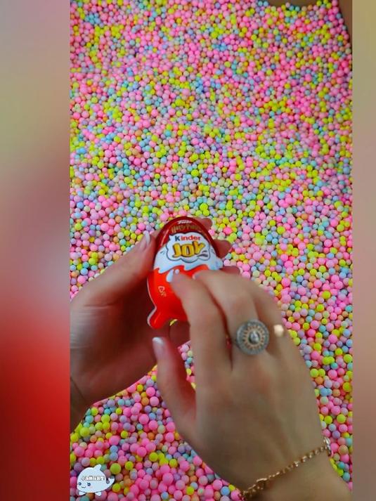 在彩球堆里拆巧克力奇趣蛋玩具