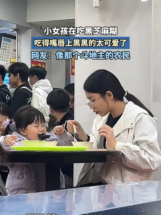 小女孩在吃黑芝麻糊,吃得嘴唇上黑黑的太可爱了