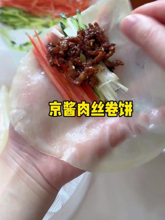 吃不完的饺子皮沾上油上锅蒸一蒸,出锅卷上京酱肉丝和配菜