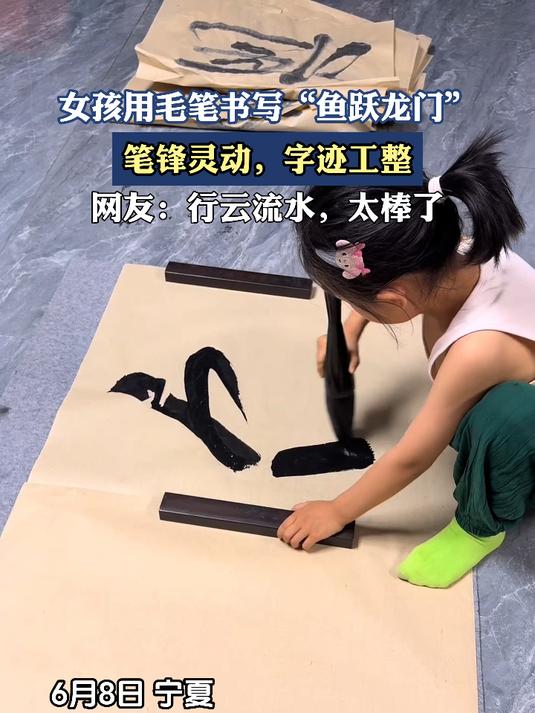 女孩用毛笔书写“鱼跃龙门”,笔锋灵动,字迹工整