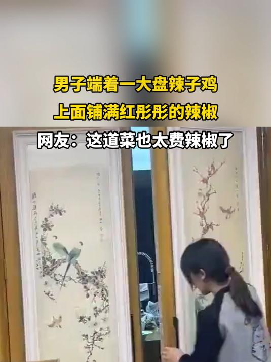 男子端着一大盘辣子鸡,上面铺满红彤彤的辣椒
