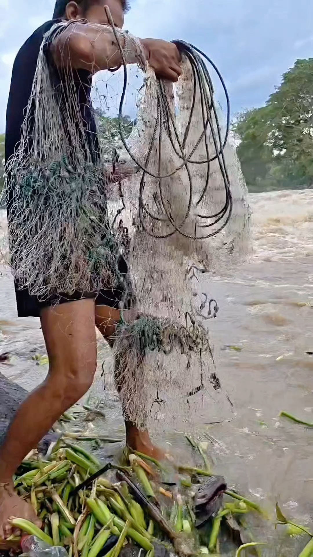 男人在湍急的河流中撒网捕鱼，他能捕到鱼吗