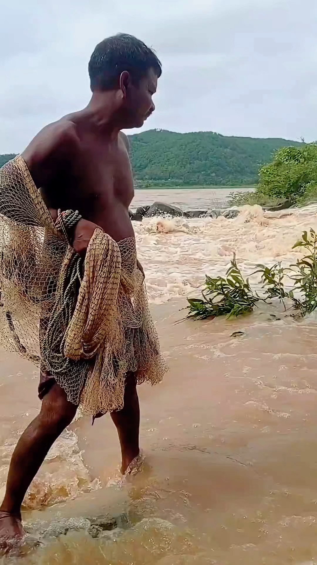 男人在波涛汹涌的河中撒网捕鱼，他能捕到鱼吗