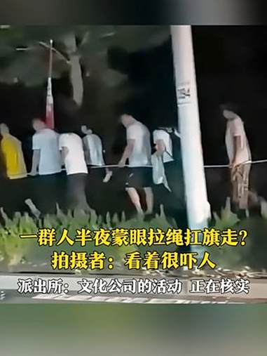 7月13日，淄博，网友发布视频称：在文昌湖人行道，一群人半夜蒙着眼、拉着绳子、扛着旗行走，
