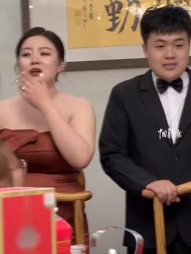 可爱现场!新郎新娘举着超大号的奶茶杯子给大家敬酒。(中国青年报)