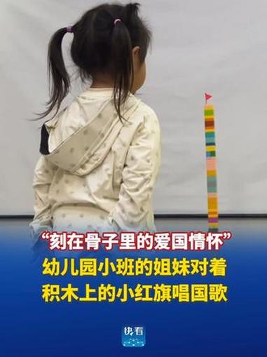 “刻在骨子里的爱国情怀”，幼儿园小班的姐妹对着自己堆起积木上的小红旗，轻声哼唱国歌。@湾了