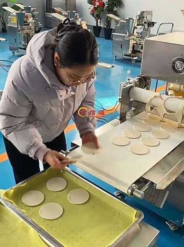 操作非常简单只需要提前把面和好,经过滚轮的压制到达成型模具这里经过模具压制荷叶饼就成型了可