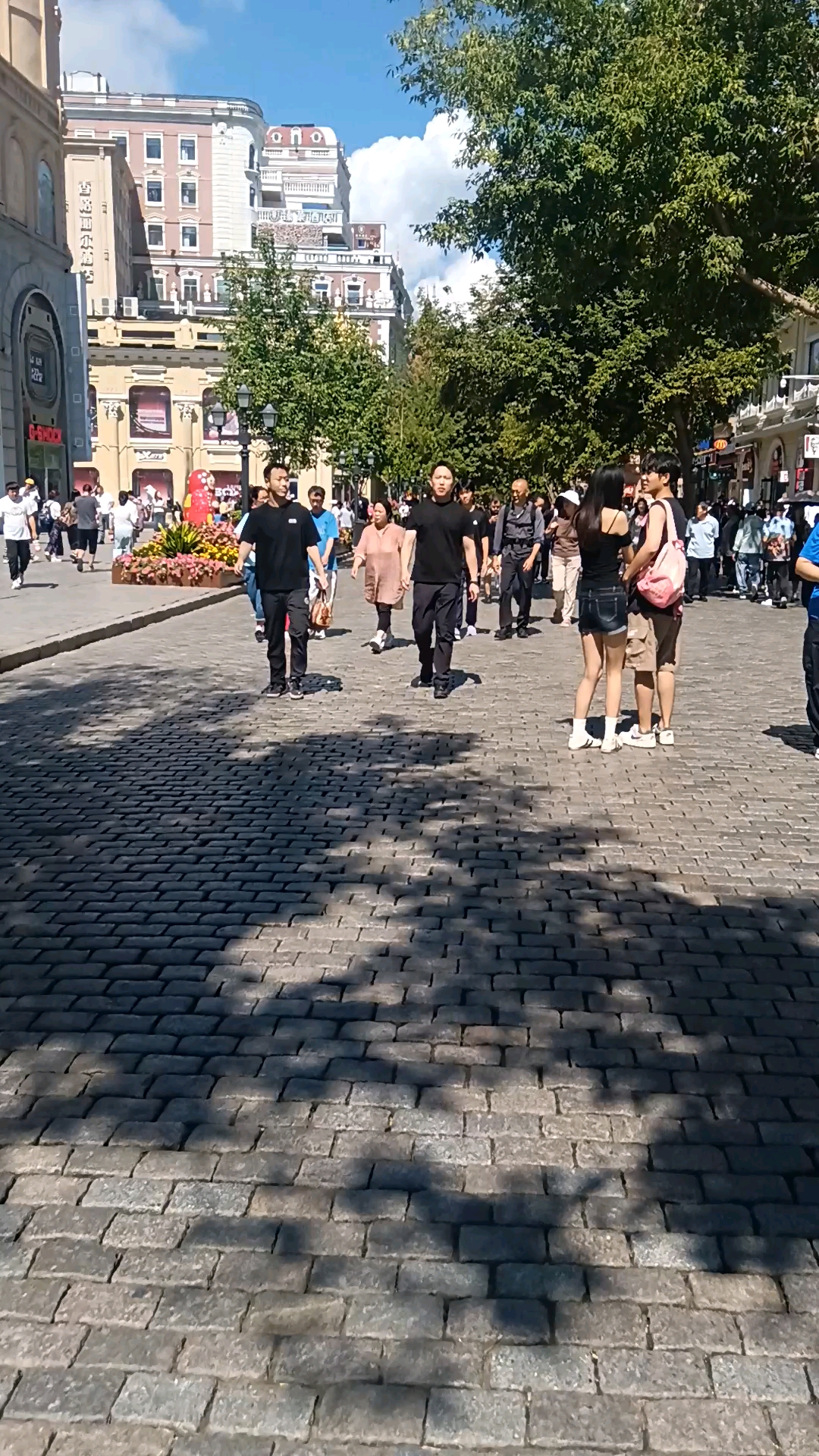 哈尔滨中央大街街道上,脚踩着百年老面包砖路,路上行人熙熙攘攘