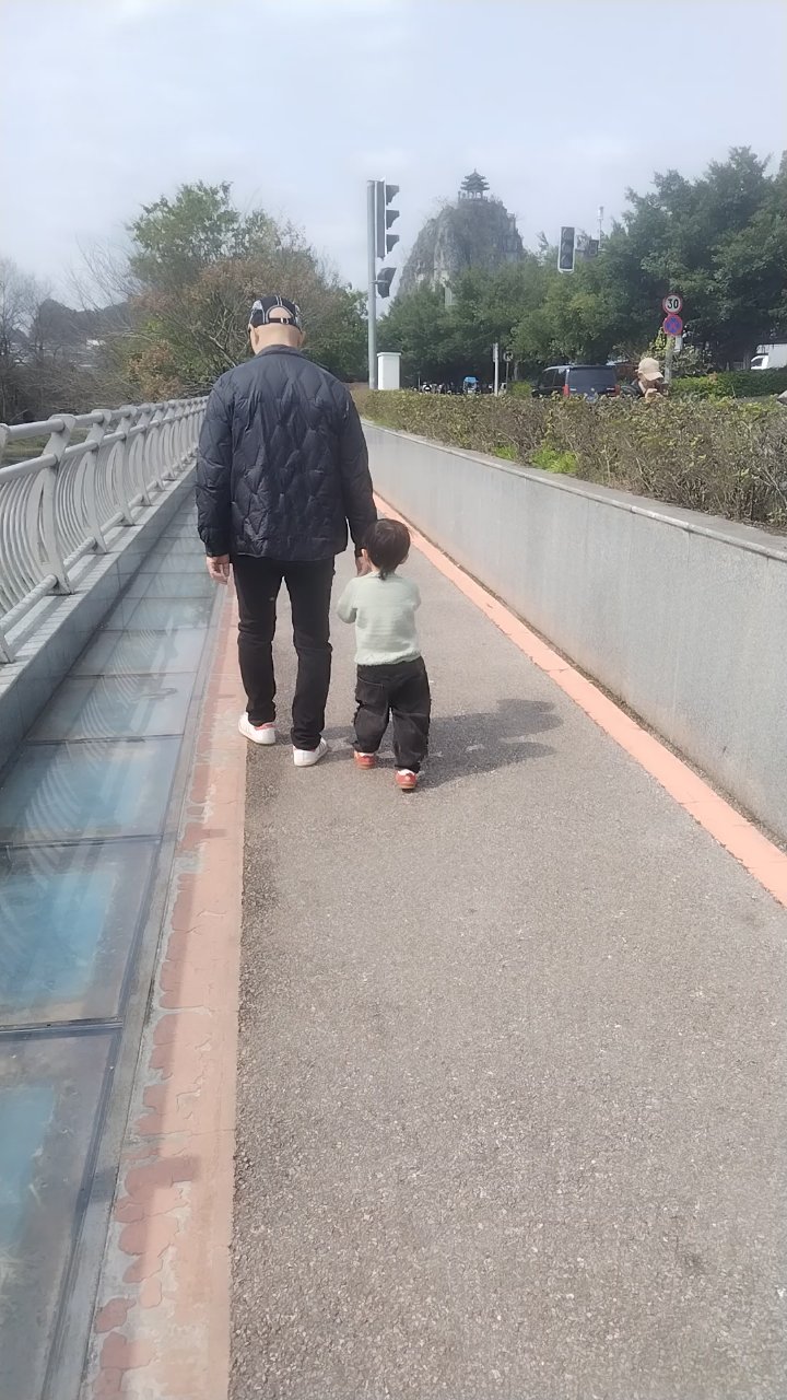 父子俩早上河边散步