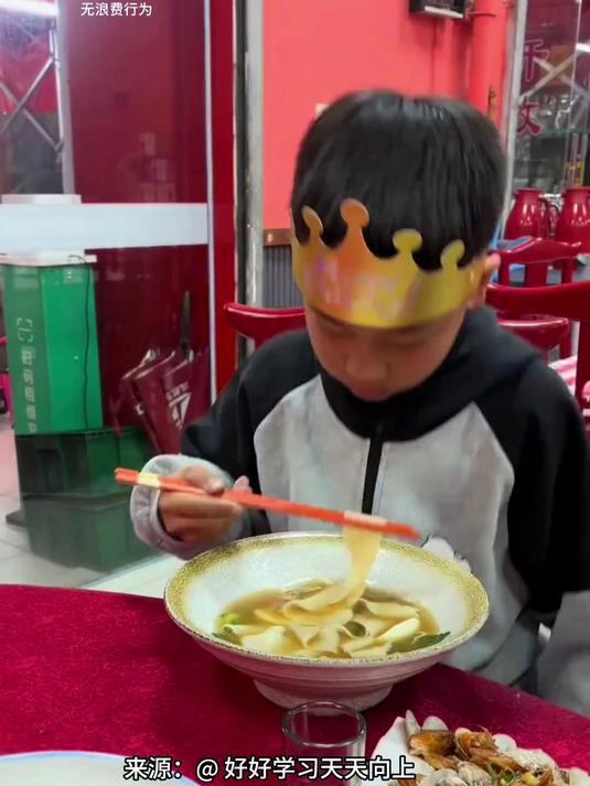 小男孩过生日吃长寿面,奈何没吃到 一筷子下去掉地上了